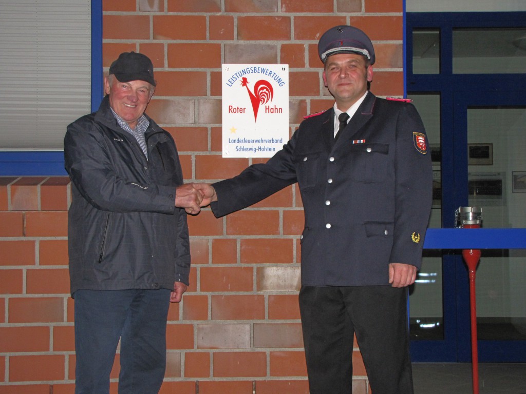 Linaus Bürgermeister Heinz Näveke gratuliert Wehrführer Stefan Schimming zum  "Roten Hahn"